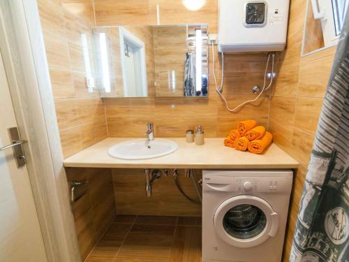 a bathroom with a sink and a washing machine at Maki Apartments - Plavi Horizonti Beach in Tivat