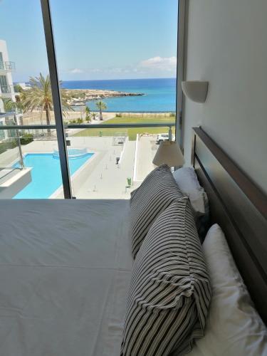 a bed in a room with a view of the ocean at Coralli Superior Seaview in Protaras