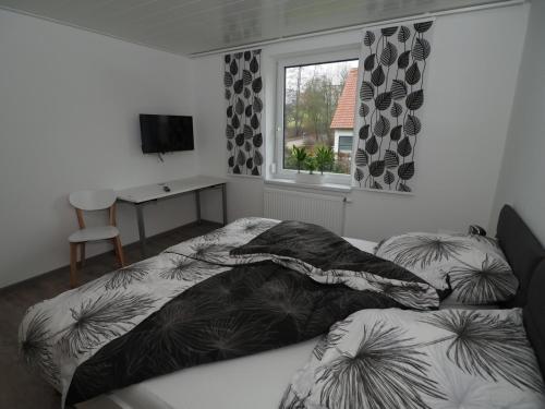 a bedroom with two beds and a window and a desk at Ferienwohnung Sanwald in Schwäbisch Hall