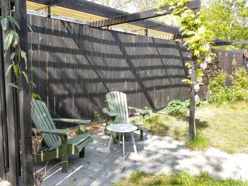 two green chairs and a table in a backyard at Finca Vrij in Scharendijke