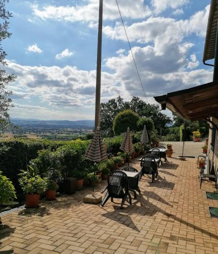 a group of tables and chairs on a brick patio at Camere da Anna Maria in Assisi