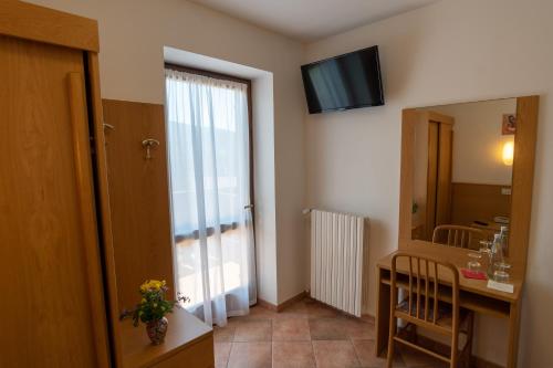 a room with a desk and a door with a mirror at Casa Santa Maria in Folgaria