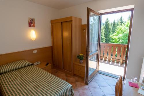 a bedroom with a bed and a sliding glass door at Casa Santa Maria in Folgaria