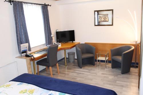 a room with a desk with chairs and a computer at Hotel Restaurant Post Italia in Albstadt