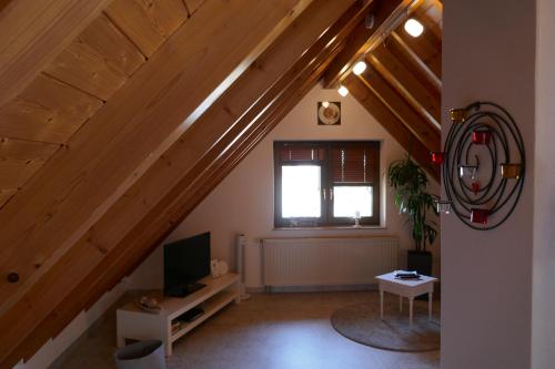 a living room with wooden stairs with a tv at Ferienwohnung Weinbergliebe am Tuniberg zwischen Freiburg und Frankreich in Merdingen