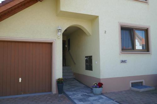 a house with a brown garage door and a window at Ferienwohnung Weinbergliebe am Tuniberg zwischen Freiburg und Frankreich in Merdingen