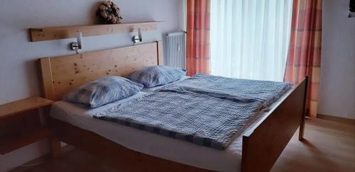 un letto con due cuscini sopra in una stanza di Ferienwohnung Alpenveilchen im Oberallgäu a Missen-Wilhams