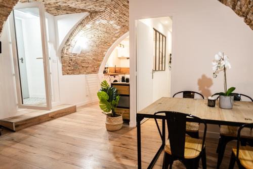 une salle à manger avec une table et des chaises en bois dans l'établissement Les Voûtes du Vieux-Port, à Marseille