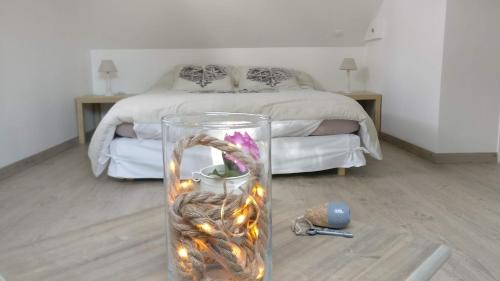 a bedroom with a bed and a glass vase with lights at Les Chambres de Pascaline in Arrest