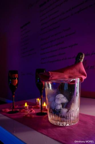 a fishtank with a red hat on a table with glasses at Désir'ôôm in Cabannes