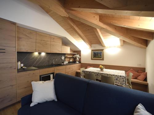 a living room with a blue couch and a table at Europa Mountain Apartments in Alleghe