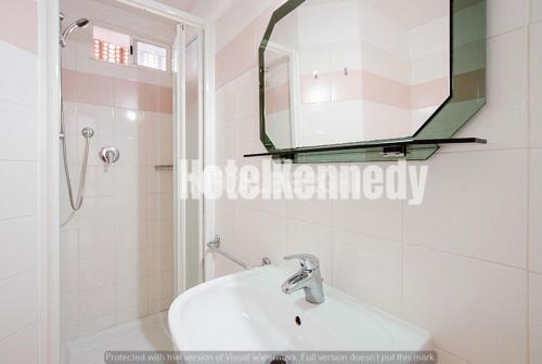 a white bathroom with a sink and a mirror at Hotel Kennedy in Lido di Savio