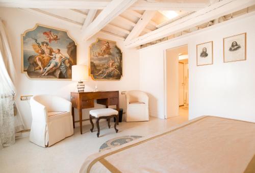 een slaapkamer met een bed, een bureau en stoelen bij WellVenice Fenice in Venetië