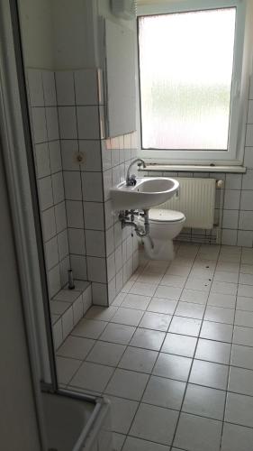 a bathroom with a sink and a toilet and a window at Natur-Freude1-16 in Rhinsmühlen