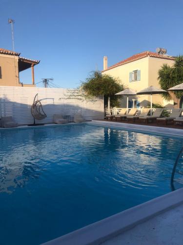 une grande piscine bleue en face d'une maison dans l'établissement Bay's, à Spetses