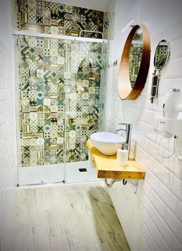 a bathroom with a sink and a shower at Apartamentos Villas Romanas in Mérida
