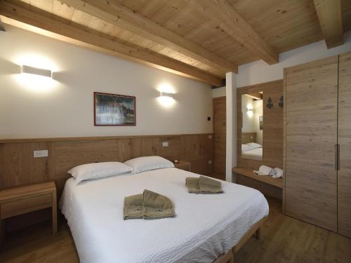 a bedroom with a large bed with two pillows on it at Europa Mountain Apartments in Alleghe
