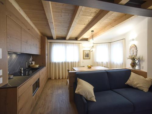 a living room with a couch and a kitchen at Europa Mountain Apartments in Alleghe