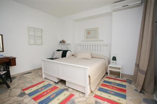 1 dormitorio con cama blanca y alfombra en Depadansa Lisette, en Crikvenica