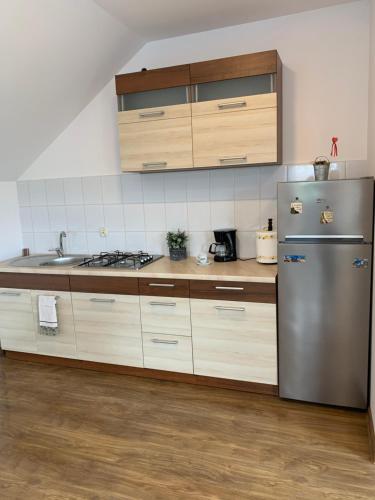 a kitchen with a stainless steel refrigerator and a sink at Mazurski dom Brejdyny Sauna i Bania in Mrągowo