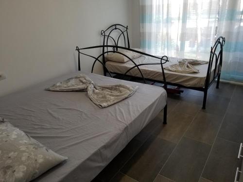 - une chambre avec 2 lits et une fenêtre dans l'établissement Beach Veranda Home, Gjiri i Lalzit, à Durrës