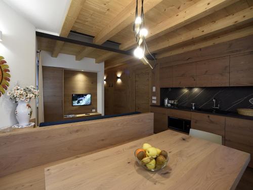 a kitchen with a bowl of fruit on a wooden table at Europa Mountain Apartments in Alleghe