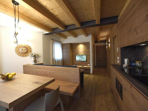 a kitchen with a wooden table and a dining room at Europa Mountain Apartments in Alleghe