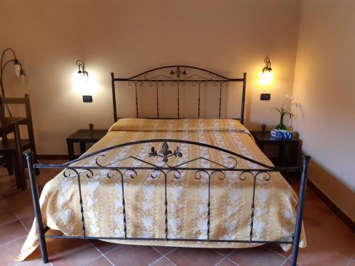 a bed in a bedroom with two tables and two lamps at Agriturismo Il Pozzo Antico in Mascali