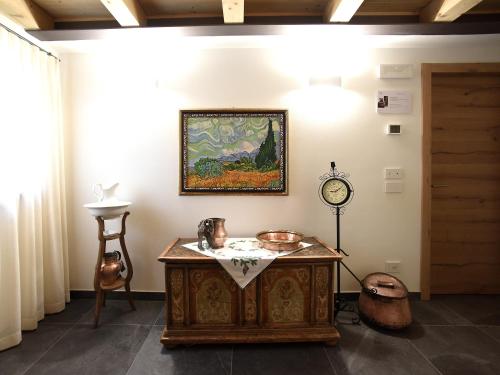 a room with a table and a clock on the wall at Europa Mountain Apartments in Alleghe