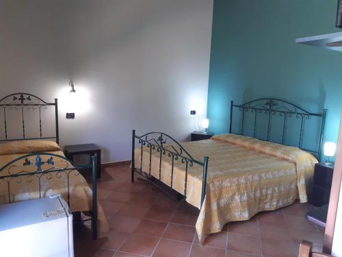 a bedroom with two beds in a room at Agriturismo Il Pozzo Antico in Mascali