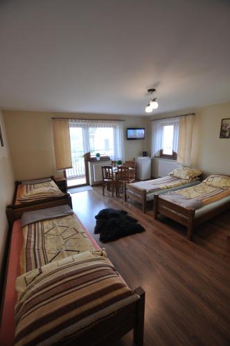 a room with three beds and a living room at Noclegi Barbara Pietraszek in Krempachy