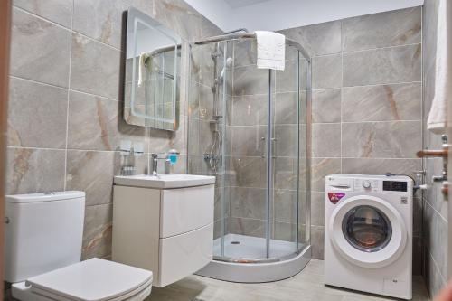 a bathroom with a shower and a washing machine at Fanta Sea Apartament Spa n Pool Beach resort in Mamaia Sat/Năvodari