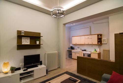 ein Wohnzimmer mit einem TV und einer Küche in der Unterkunft Via Domus in Athen