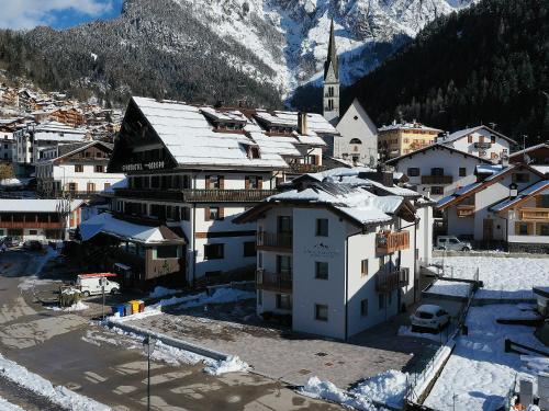 a small town with a church and a snowy mountain at Europa Mountain Apartments in Alleghe