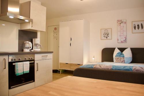 a small bedroom with a bed and a kitchen at Herzog Wolfgang Studios- Zentral, Modern, Freundlich in Zweibrücken