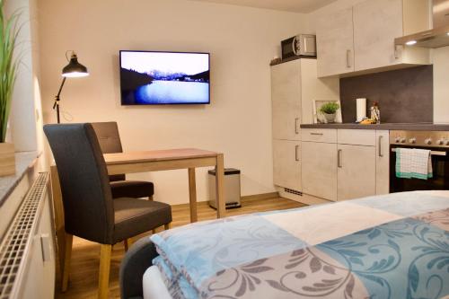 a bedroom with a desk and a table and a kitchen at Herzog Wolfgang Studios- Zentral, Modern, Freundlich in Zweibrücken