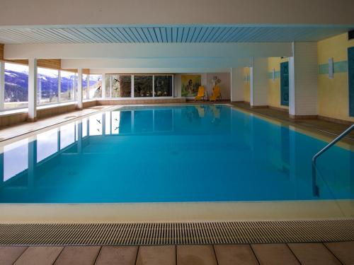 a large swimming pool with blue water at Grimming view Apartment in Tauplitz