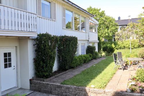 克里斯蒂安桑的住宿－Praktisk leilighet i Kristiansand til 5，院子里的白色房子,配有桌椅