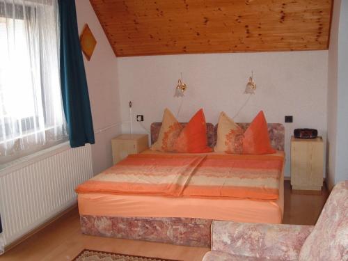 a bedroom with a large bed with orange pillows at Apartman Hévíz Holiday in Hévíz