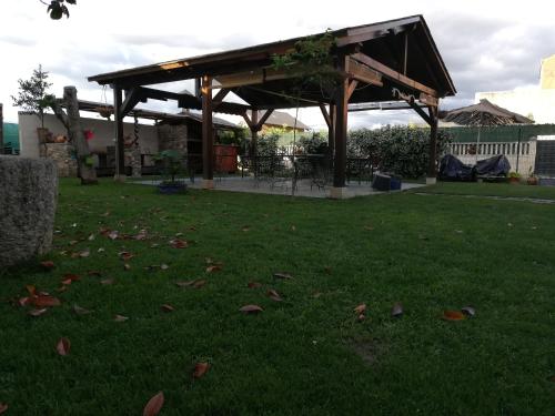 a gazebo in a yard with leaves on the grass at Albergue la Medina de Camponaraya in Camponaraya
