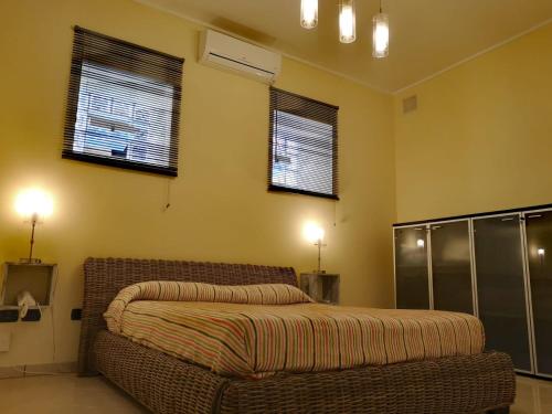 una camera con un letto e due finestre di Loft_166 a Sellia Marina