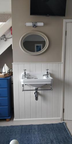 a bathroom with a sink and a mirror at Anchorage Guest House, St Ives in St Ives