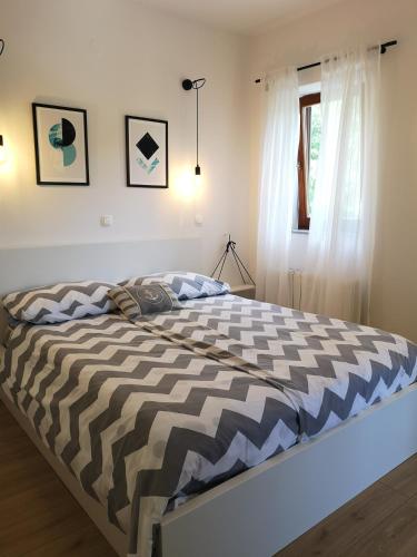 a bedroom with a bed with a striped comforter at Apartments Frgacic I in Baška