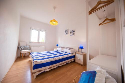 een slaapkamer met twee bedden en een raam bij Apartments Leonarda in Murter