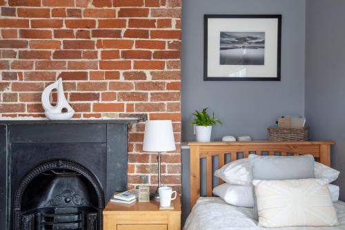 a bedroom with a brick wall and a fireplace at The Caledon Guest House in Cowes