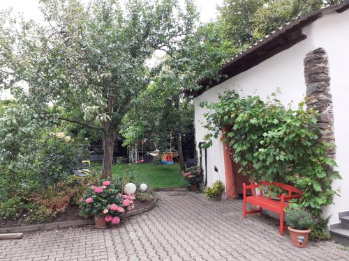 eine Terrasse mit einer roten Bank und ein paar Blumen in der Unterkunft Ferienwohnung Röschen in Bernkastel-Kues