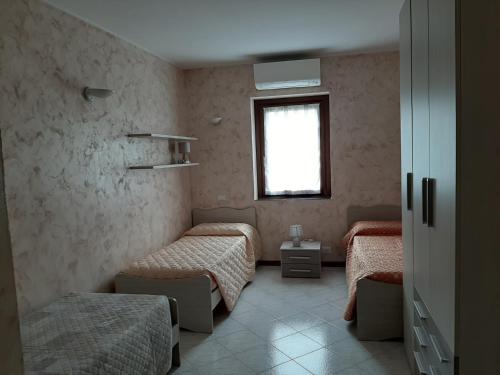 una camera con tre letti e una finestra di Casa Bibì a Bergamo