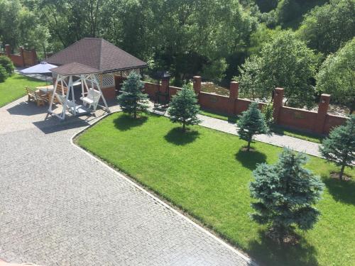 einen Luftblick auf einen Garten mit einem Pavillon in der Unterkunft Шале Золота пiдкова та рiчка in Slawske