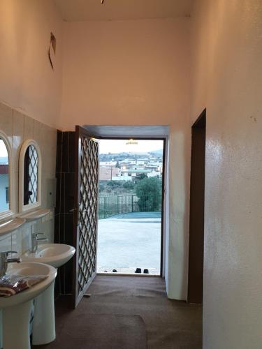 a bathroom with two sinks and a door to a yard at منزل ريفي بناء حجري in Al Assan