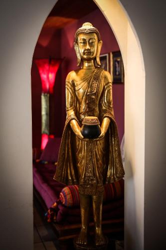 a gold statue of a man standing in a room at The River Village in Interlaken